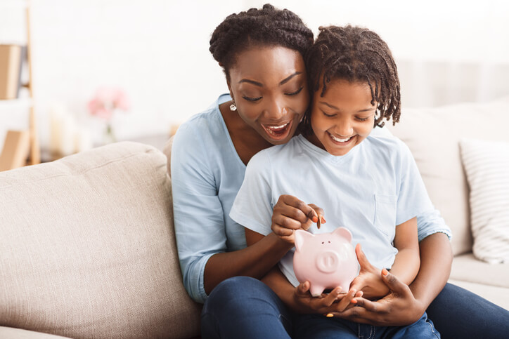 woman teaching child how to save money