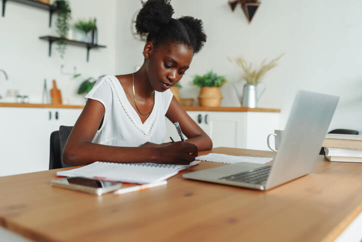 woman writing in a journal fro wellness practice